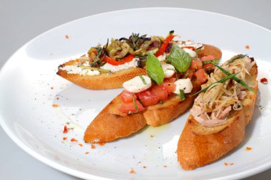 İtalyan bruschetta ile somon, ton balığı, mozzarella ve beyaz tabakta ızgara sebze..