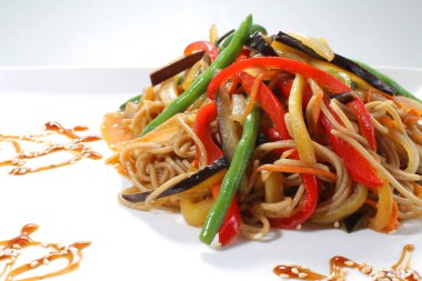 Beyaz tabakta ızgara sebzeli soya eriştesi..