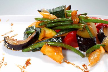 Beyaz tabakta teriyaki soslu ızgara sebze..