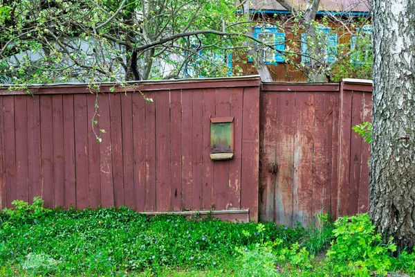 Old red rickety wooden fence in an eastern european village — Stock Photo, Image