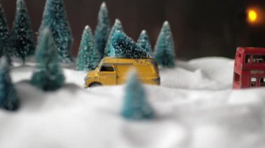 Çatıda bir Noel ağacı ile küçük bir sarı oyuncak araba ile Kış orman minyatür, çift katlı kırmızı otobüs, kar yığınları ve Noel ağaçları.