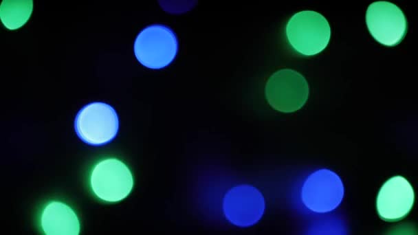 Im Hintergrund blinkt die Weihnachtsbeleuchtung. farbenfrohes Bokeh — Stockvideo