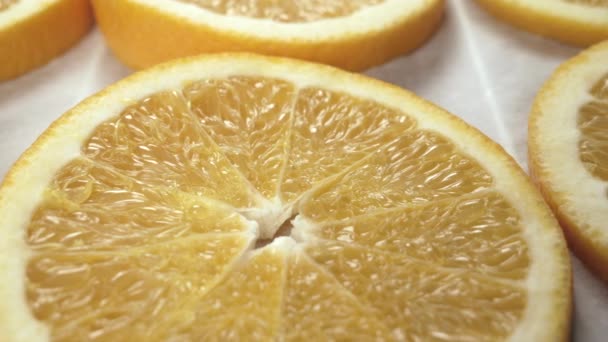 Tranches d'orange fraîches sur papier cuisson. Ferme là. Mouvement latéral du curseur — Video