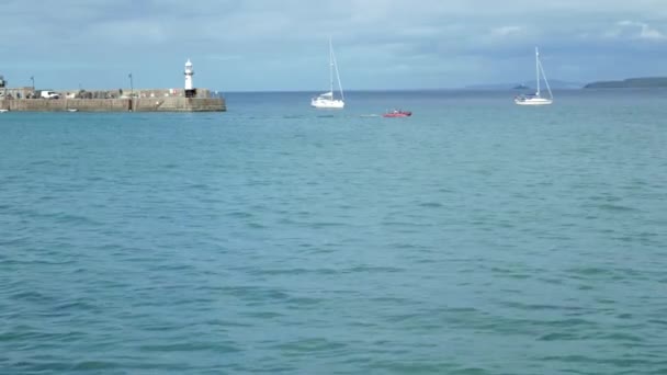 Perahu karet merah bermotor mengapung di teluk di latar belakang kapal pesiar — Stok Video