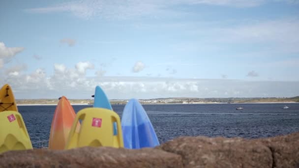 Стоячі барвисті каяки на фоні моря — стокове відео