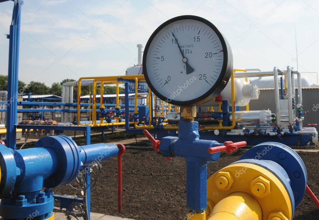 The pressure gauge is on the gas compressor station in a sunny summer day