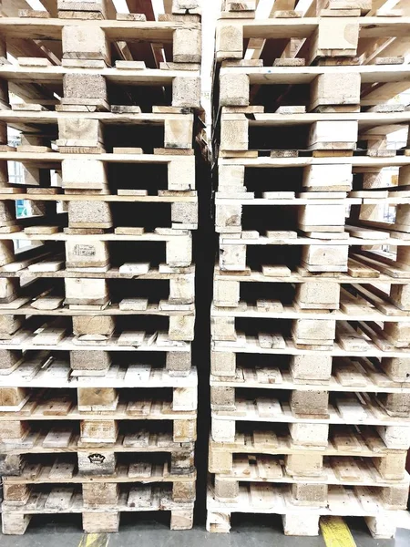 Many pallets stacked in stock, warehouse pallets, blue wooden pallets