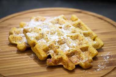 tahta bir tahta üzerinde pudra şekeri ile havuç waffle. Mükemmel sağlıklı kahvaltı.