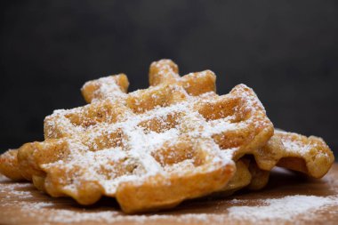 Havuç waffle ahşap bir tabak üzerine pudra şekeri serpilir
