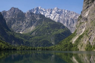 bahar dağlarda kristal berraklığında su ile göl. Bir sahilden Alpler manzaralı küçük bir göl. Alp gölünün suda dağların yansıması