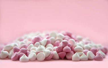 pembe ve beyaz mini Meringues kırmızı bir arka planda yalan damla şeklinde. Metin için Yerleştir