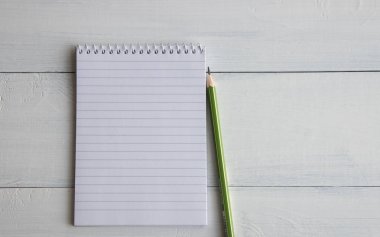 bir cetvel, boş bir sayfa ve bir kalem beyaz ahşap bir masanın yanında yalan defter açık. Metin için yer. Kopyalama alanı.