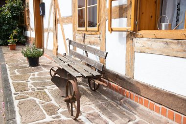 Eski, yarı ahşap bir evin penceresinin altında eski ahşap bank. eski bir Avrupa köyünün sessiz sokak