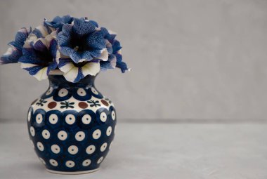 Vazoda mavi petunya buketi. Gri bir arka plan üzerinde desen li mavi vazo mavi, mavi çiçekler buket