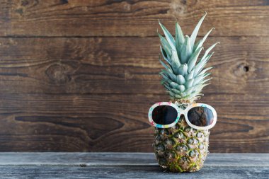Kavramsal tatil, turizm, seyahat tropik meyveler, arka planda güneş gözlüklü ananas. Boşluğu kopyala.