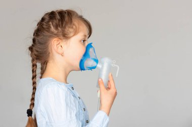 Solunum için maske takan beyaz bir kız. Bronşiti önleme, evde solunum. Boşluğu kopyala.