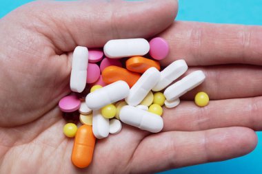 İçinde bir avuç dolusu renkli hap, antibiyotik, hap ya da kapsüller olan bir avuç dolusu yakın plan. Tıbbi konsept. İlaç tedavisi. Ellerdeki sağlık.