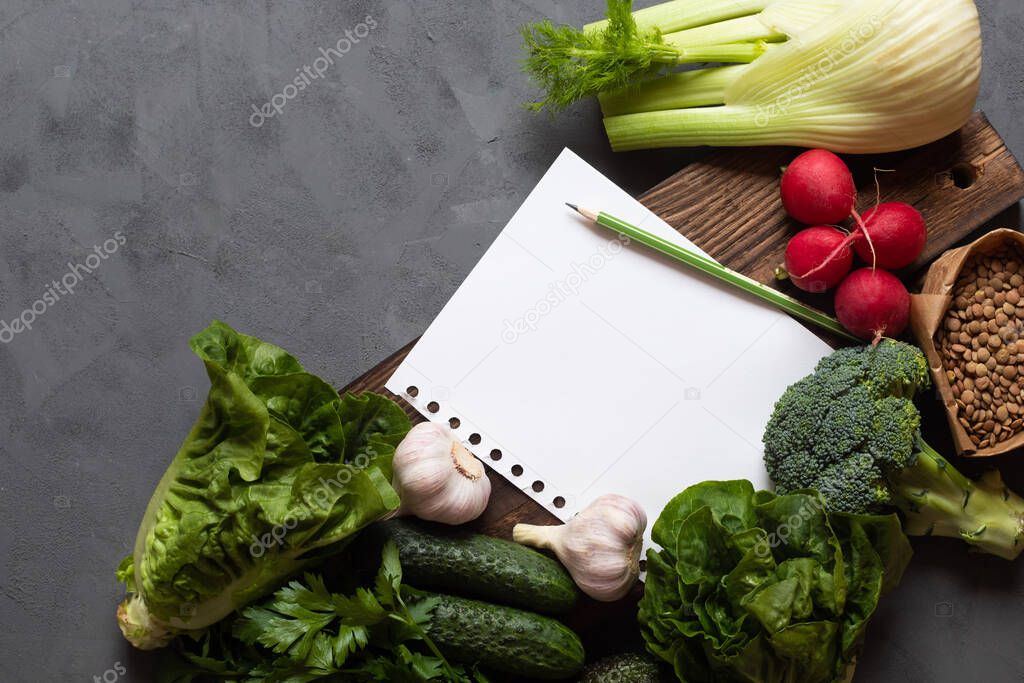 Shopping list, diet, nutrition, weekly menu, grocery shopping. Vegetables lie next to a white piece of paper. Place for text. Healthy eating
