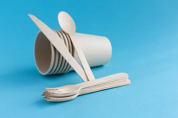 环保即弃纸杯和餐具 由木制勺子 叉子和刀具制成 蓝色背景 零浪费的概念 案文的位置 — 图库照片