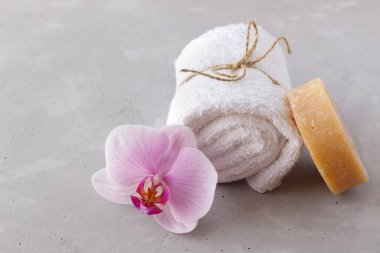 Spa salonu, yüz ve vücut bakımı, masaj odası ya da güzellik uzmanı konsepti. Beyaz banyo havlusu ve orkide. Boşluğu kopyala.
