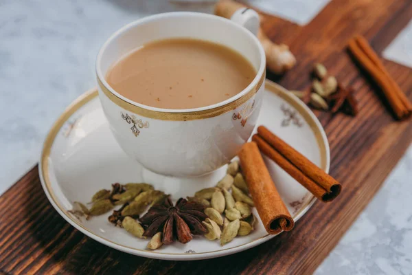 玛莎拉茶香喷喷的茶 传统的印度热饮料 在瓷杯的木板上有各种调味品 — 图库照片