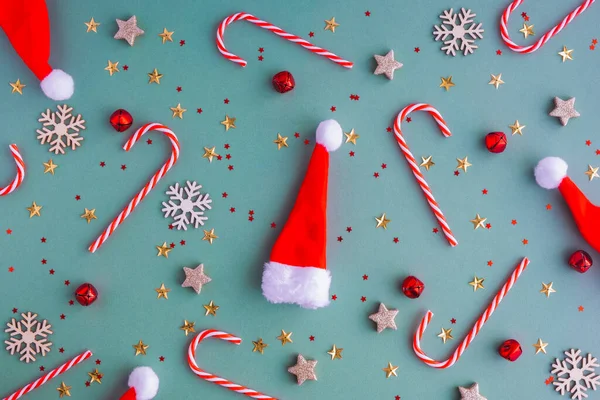 Nový rok nebo vánoční pozadí. Ploché lei z klobouků Santa Claus a vánočních hraček a lízátek. Perfektní řešení pro novoroční přání — Stock fotografie