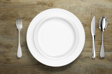 Gümüş çatal bıçaklı beyaz porselen yemek takımı.