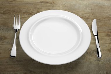 Gümüş çatal bıçaklı beyaz porselen yemek takımı.
