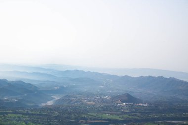 Mavi sis bir tepenin zirvesinden geniş bir açıyla dağları kapladı.. 