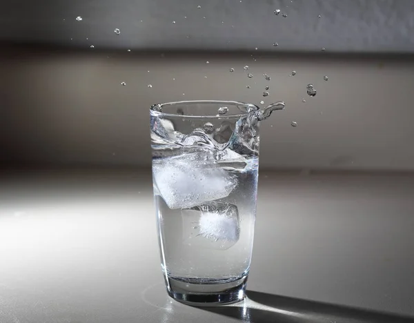 Ice Stänk Ett Glas Vatten Bänkskiva — Stockfoto