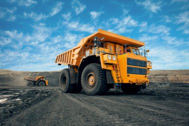 Kömür madeninde büyük bir taş ocağı kamyonu. Kamyona kömür yüklüyorlar. Minerallerin taşınması için maden ekipmanları.
