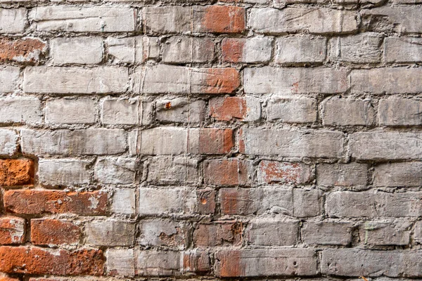 Vieux mur antique de briques rouges détruites. Du plâtre blanc a été appliqué sur la maçonnerie. Le plâtre est fissuré. — Photo