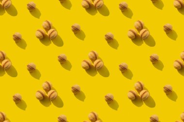 Sarı arka planda tekrarlanan cevizli kurabiye kalıbı. Kusursuz doku.