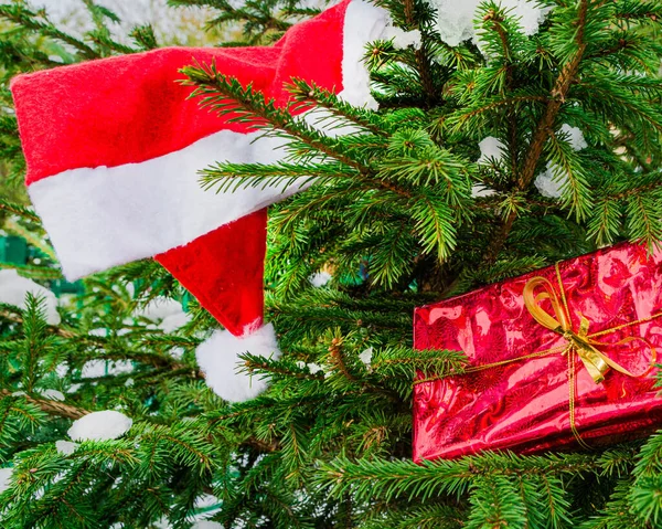 Sombrero rojo de Papá Noel, rama de árbol de Navidad y caja de regalo. Símbolos tradicionales de Año Nuevo y Navidad — Foto de Stock