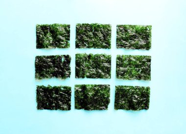 Kurutulmuş yosun ve yemek çubukları. Beyaz seramik plaka, yosun levhalar, makro, yakın çekim üzerinde Nori yongaları. Sağlıklı gıda konsepti.üst görünüm, düz yatıyordu.