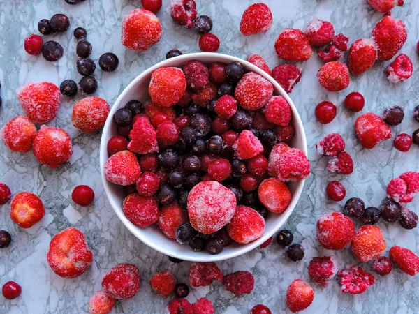 Berenjenas congeladas.Vista superior. Deliciosas bayas congeladas sobre fondo azul, primer plano. Surtido de bayas congeladas de fondo. Frambuesas, grosellas negras y fresas sobre fondo azul, espacio para copiar . — Foto de Stock