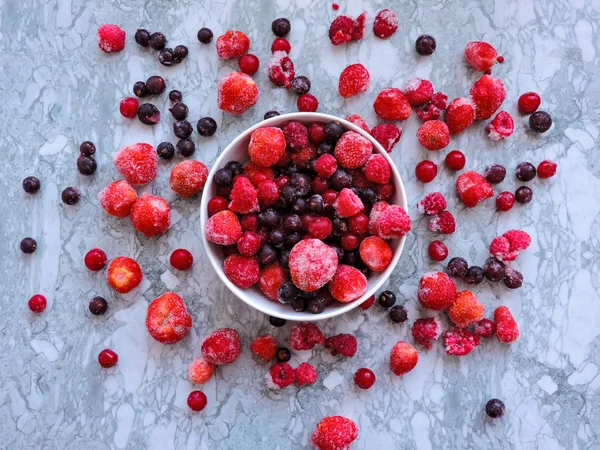 Raspberries, black currant and strawberries on blue background, copy space. — Stock Photo, Image