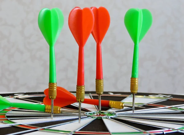 Dart arrow hitting in the target center of dartboard. Success hitting target aim goal achievement concept background.Darts and dart board.Close up shot of the dart arrow.Marketing concept. Dartboard.