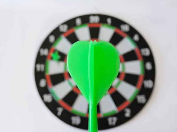 Dart arrow hitting in the target center of dartboard. Success hitting target aim goal achievement concept background.Darts and dart board.Close up shot of the dart arrow.Marketing concept. Dartboard.