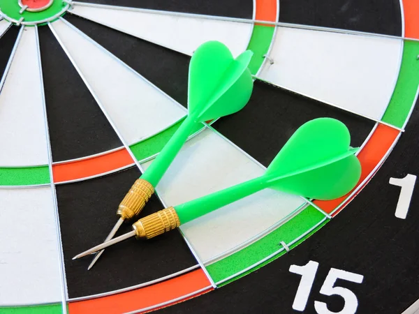 Dart arrow hitting in the target center of dartboard. Success hitting target aim goal achievement concept background.Darts and dart board.Close up shot of the dart arrow.Marketing concept. Dartboard.