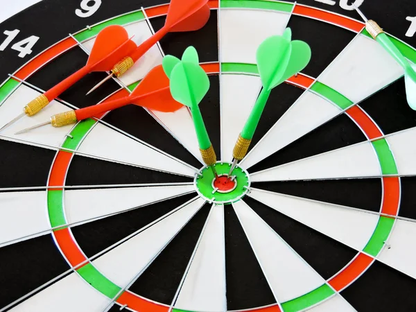 Dart arrow hitting in the target center of dartboard. Success hitting target aim goal achievement concept background.Darts and dart board.Close up shot of the dart arrow.Marketing concept. Dartboard.