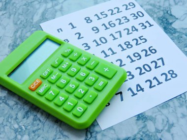 Bir proje planlama-Yakınla. Meşgul, çalışma alanı için takvim konseptinde raptiye. İş toplantısı programı, seyahat planlama veya proje çalışması ve hatırlatma konsepti. Gün ve tarihleri içeren masa takvimi. Üstte görüntü