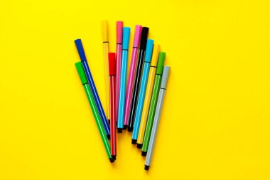 Sarı arka plan üzerinde çok renkli keçeli kalemler. En iyi görüntü, iş, ofis malzemeleri. Okul ofis malzemeleri. Minimal tarzı. Renkli marker kalem seti. Canlı vurgulayıcı. Sanat, atölye, zanaat konsepti.