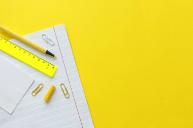 Sarı arka planda okul malzemeleri. Metin için alan ile okul kavramına geri dön. Üst te. Kopya alanı. Okul ofis malzemeleri. Renkli kırtasiye ile yaratıcı masa. Renkli ataş.