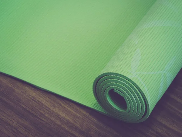 Woman rolling her YRolled up yoga mat isolated on white. Copyspace.