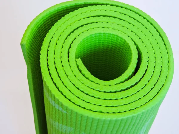 Woman rolling her Yoga mat after a workout - top view.Healthy life, keep fit concepts.Equipment for yoga. Top view green yoga mat sport isolated.Rolled up yoga mat isolated on white. Copyspace. — 스톡 사진