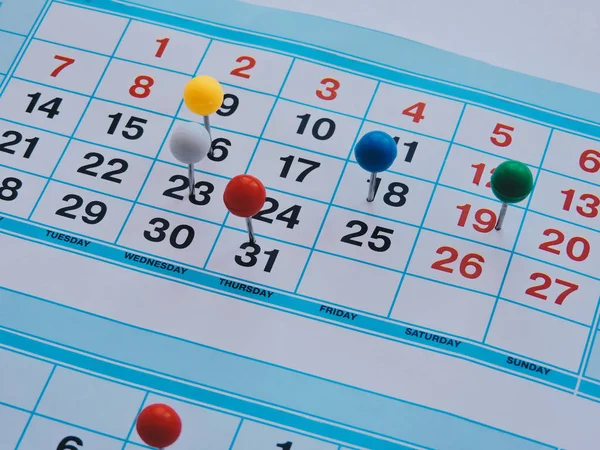 Planning a project-Close up.Thumbtack in calendar concept for busy,work space.Business meeting schedule, travel planning or project work and reminder concept.Desk calendar with days and dates.Top view — Stock Photo, Image