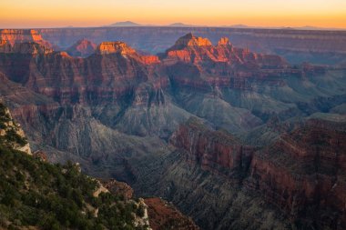 Güney tarafında gün batımında Büyük Kanyon, onun yangın gibi görünüyor ve altın ışık kanyon zirveleri kapalı parlıyor