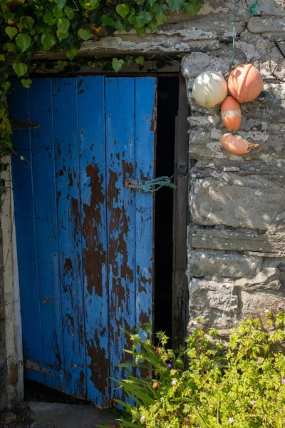 Een open gebroken geschilderde deur open gehouden met een stukje string van een traditionele stenen gebouw in Ierland — Stockfoto