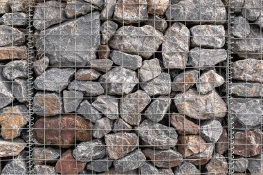 Sel önlemede kullanılan metal bir kafesteki granit kayayığının, kafesin bükülmüş eklemini göstermesi